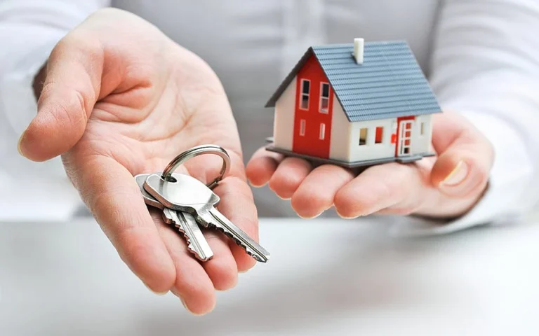 a person holding a house and keys